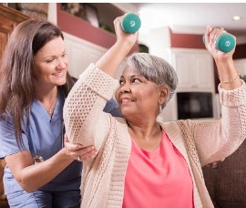 Home Care Specialist doing physical therapy with senior woman. 