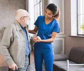 Home Care Specialist helping senior man walk. 