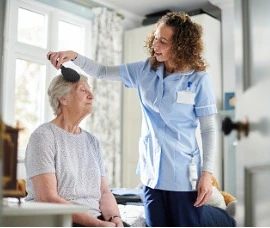 Home Care Specialist helping woman in the morning. 